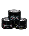 Three black hair product jars labeled 'Oceanic Grit', 'Butter Blend', and 'Fruit Fusion' on a white background.